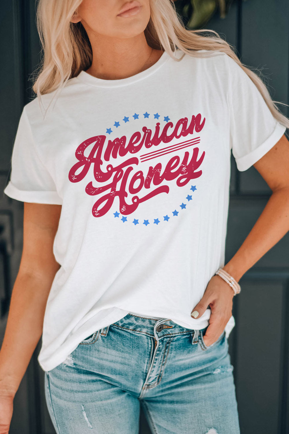 white tee with red lettering that says "American Honey", a cirlce of little blue starts surrounds the letters